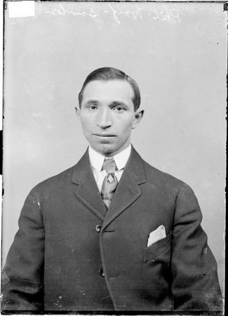 Bowler Phil Wolf, facing the camera, sitting in front of a light-colored backdrop in a room - Chicago Daily News, Inc.