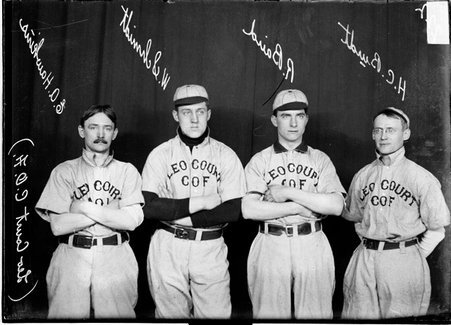 Leo Court C. O. F. indoor baseball players W. Schmidt, R. Baird, H. C. Burdt, and E. A. Hawkins standing in front of a backdrop - Chicago Daily News, Inc.