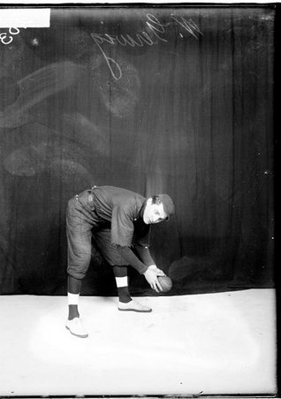 George Young & Co. indoor baseball player Gerwig, leaning forward and holding a baseball, in front of a backdrop, light exposure - Chicago Daily News, Inc.
