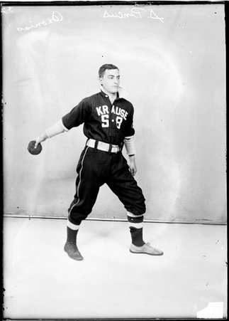 Oxonias indoor baseball player S. Pincus, holding an indoor baseball in his right hand, extended behind him, standing by a backdrop - Chicago Daily News, Inc.
