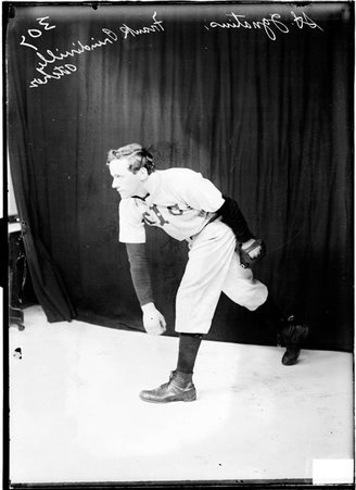 St. Ignatius pitcher Frank Prindiville, posing as if following through after throwing a baseball, standing in front of a backdrop - Chicago Daily News, Inc.