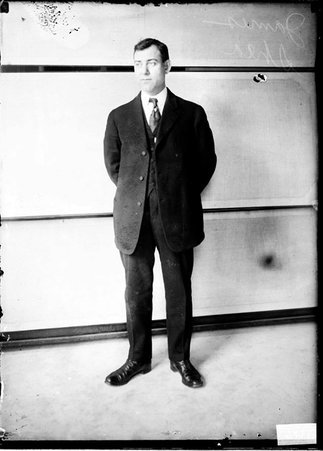 James Shea standing in front of a light-colored backdrop - Chicago Daily News, Inc.