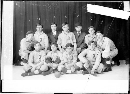 West Park No. 3 indoor baseball team members sitting and kneeling in front of a dark backdrop - Chicago Daily News, Inc.