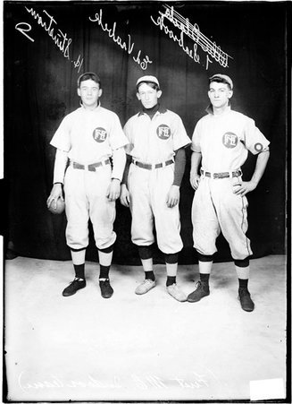 First Methodist Episcopal indoor baseball players H. Stenstrom, Ed Vrabek, and T. Seabrook, standing in front of a dark backdrop - Chicago Daily News, Inc.