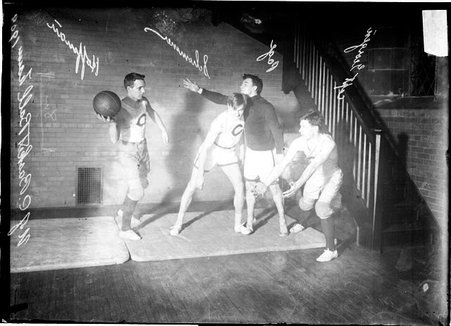 University of Chicago basketball players Hoffman, Schommer, Georgen, and Page posing on a mattress in front of a brick wall in a room - Chicago Daily News, Inc.