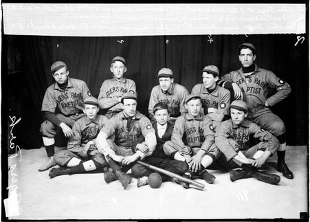 Rogers Park indoor baseball team members posing in front of a dark backdrop - Chicago Daily News, Inc.