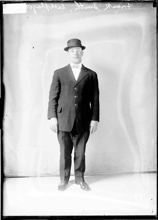 Chicago White Sox baseball player Frank Smith, wearing a suit and hat, standing in front of a light-colored backdrop - Chicago Daily News, Inc.