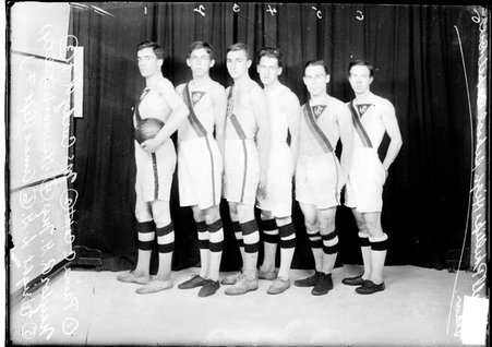 Wendell Phillips High School basketball players standing in front of a dark backdrop, light exposure - Chicago Daily News, Inc.