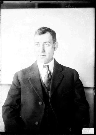 James Shea sitting in front of a light-colored backdrop - Chicago Daily News, Inc.