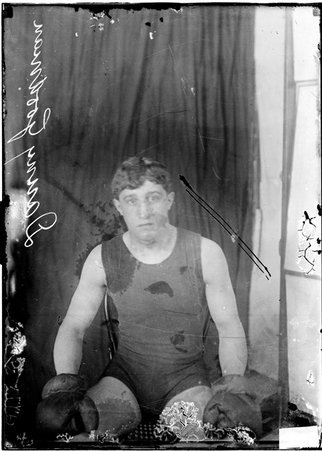 Boxer, Danny Goodman, sitting in front of a dark backdrop - Chicago Daily News, Inc.
