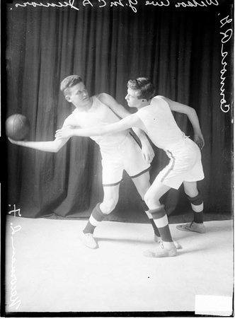 Wilson Avenue YMCA Juniors basketball players, right forward Newman and right guard Connors, standing in front of a backdrop - Chicago Daily News, Inc.
