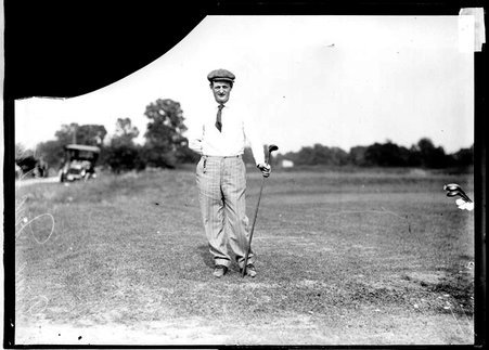 Golfer D. McIntosh, holding a golf club, standing on the grounds of an unidentified golf club - Chicago Daily News, Inc.