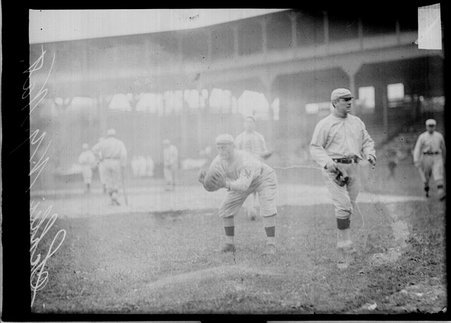 New York Giants baseball player Admiral Schlei, leaning forward to catch a baseball, standing on the field at West Side Grounds - Chicago Daily News, Inc.