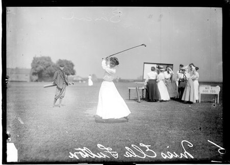 Golfer, Ella Fulton, swinging a club into a top-of-the-backswing position, standing on the first tee on of an unidentified golf course - Chicago Daily News, Inc.