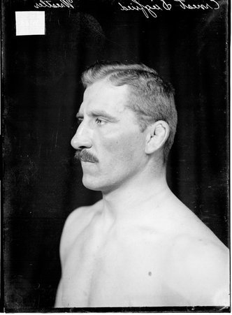Wrestler Ernest Siegfried, posing in front of a dark backdrop - Chicago Daily News, Inc.