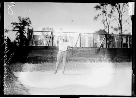 LaGrange tennis player Myers, hitting a tennis serve, standing on a tennis court - Chicago Daily News, Inc.