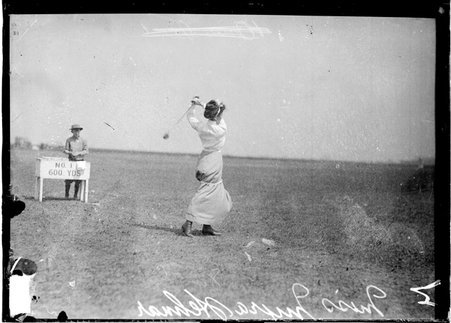 Golfer, Myra Hehmar, following through after swinging a club, standing on the first tee on the grounds of an unidentified golf course - Chicago Daily News, Inc.
