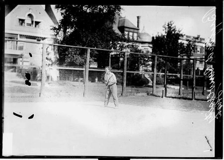 University High School tennis player Byford, holding a tennis racket, standing on a tennis court - Chicago Daily News, Inc.