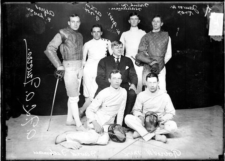 A. F. L. A. fencers, Fichman, Mix, Greve, Sauer, Fox, Hannum, and Knox, posing with foils in front of a dark backdrop - Chicago Daily News, Inc.
