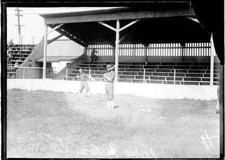 Milwaukee baseball player, Norris, holding a baseball bat, standing in front of a grandstands on a baseball field - Chicago Daily News, Inc.