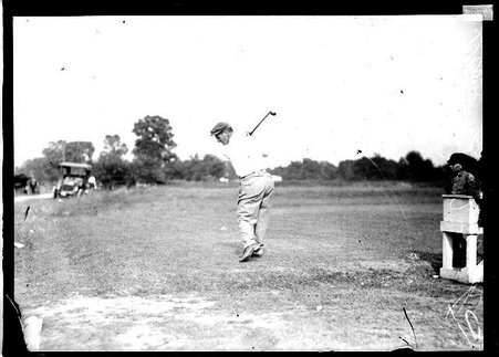 Golfer, D. McIntosh, swinging a golf club into a top-of-the-backswing position, standing on the grounds of an unidentified golf course - Chicago Daily News, Inc.