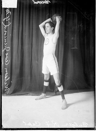 Wilson Avenue YMCA Juniors basketball captain/right forward Bulger, holding a basketball above his head - Chicago Daily News, Inc.