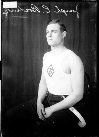 Athlete Joseph C. Borden, sitting in front of a dark backdrop - Chicago Daily News, Inc.