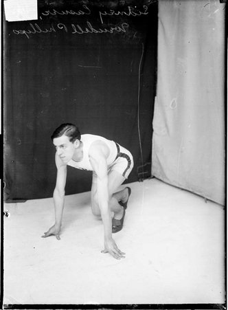 Wendell Phillips High School athlete Sidney Casner, crouching in a ready position in front of a dark backdrop - Chicago Daily News, Inc.