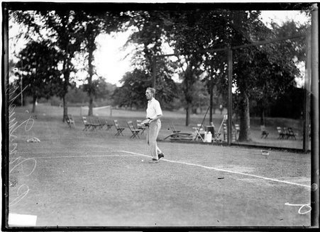 Tennis player, P. McQuiston, holding a tennis racket, standing on a tennis court - Chicago Daily News, Inc.