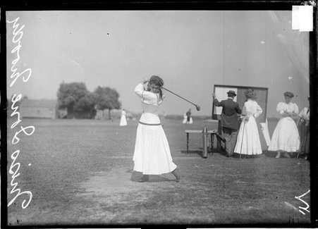 Golfer, Ione Moody, swinging a club into a top-of-backswing position, standing on a tee at an unidentified golf course - Chicago Daily News, Inc.