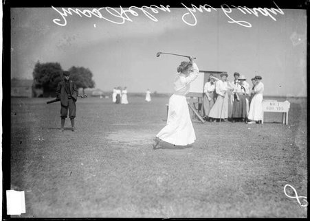 Golfer, Helen McCurdy following through after swinging a club, standing on first tee of an unidentified golf course, light exposure - Chicago Daily News, Inc.