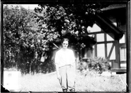 Golfer, Mason E. Phelps, standing in front of a building on the grounds of an unidentified golf club - Chicago Daily News, Inc.