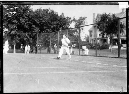 Tennis player, T. C. Bundy, drawing his arm back to hit a backhand tennis shot, standing on a tennis court - Chicago Daily News, Inc.