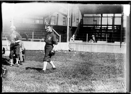 Milwaukee baseball player, Helgendorf, following through after throwing a baseball, standing in front of grandstands - Chicago Daily News, Inc.