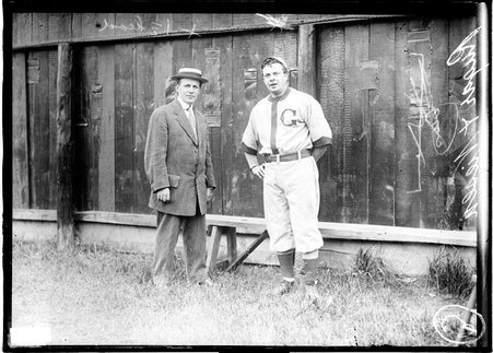 U. S. League baseball players, Ruger and Niesen, standing in front of a bench and a wooden fence on a grass field - Chicago Daily News, Inc.