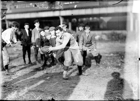 Football player, Norman Cahn, quarterback for Wendell Phillips, posing with football - Chicago Daily News, Inc.
