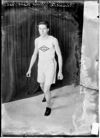 Track athlete, K. King, Crane Technical High School, standing with knees slightly bent, arms at his sides in front of dark background - Chicago Daily News, Inc.