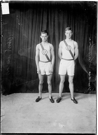 Track athletes, Lyman Stanton and Robert Langford, University High School, standing in front of dark backdrop - Chicago Daily News, Inc.