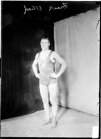 Swimmer, Frank Elliod, Illinois Athletic Club, standing with hands on hips in front of light and dark backgrounds - Chicago Daily News, Inc.