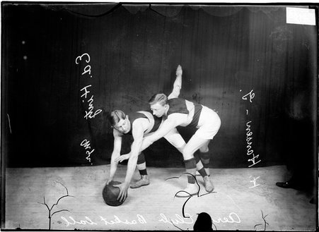 Basketball player, Ed Hintz, Aero Club, Hintz holding ball on floor, Hansen guarding him in front of dark background - Chicago Daily News, Inc.