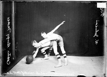 Basketball players, W. Johnson and Capt. Dingy Morse, Tabernacle Baptist, Morse scooping ball up from floor, Johnson guarding in front of backdrop - Chicago Daily News, Inc.
