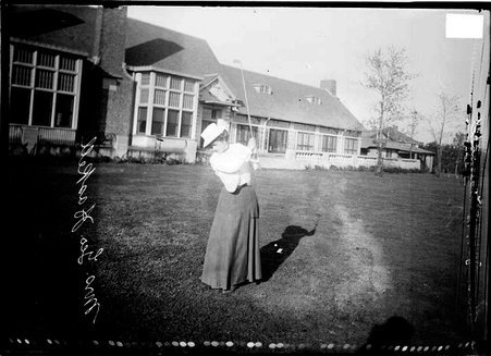 Golfer, Mrs. George S. Haskell standing on grass holding golf club over left shoulder - Chicago Daily News, Inc.