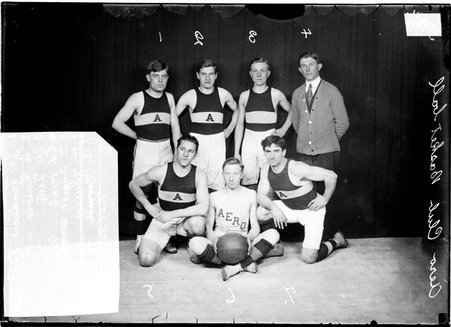 Basketball players, W. Landwer, A. Minuth, Ed Hintz, A. Larson, G. Angert, W. Lutz, Aero Club, posing in front of dark backdrop - Chicago Daily News, Inc.