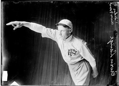 Baseball player, Erwin Lange, River Forest Federals, posing as if pitching in front of dark backdrop - Chicago Daily News, Inc.