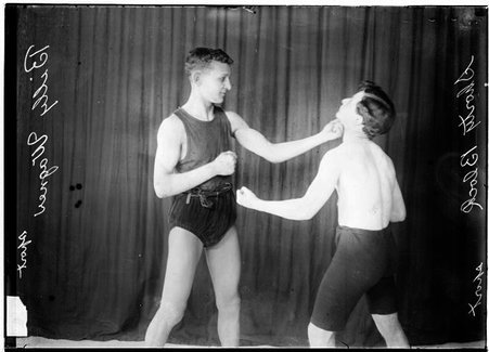 Pugilists, Billy Wagner and Shorty Block, Wagner punching Block under chin in front of dark backdrop - Chicago Daily News, Inc.