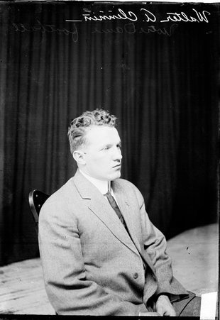 Football player Walter A. Clennan sitting in a chair facing the right side of the image in front of a dark colored background - Chicago Daily News, Inc.