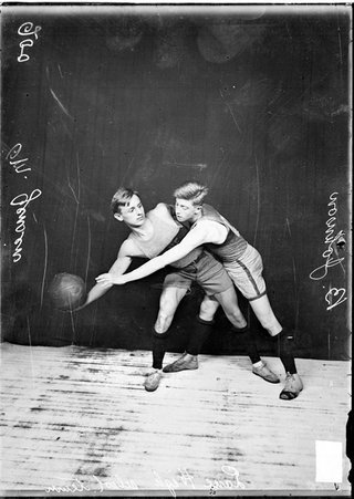 Lane High School basketball players posing with Jensen holding the ball and Johnson guarding him - Chicago Daily News, Inc.