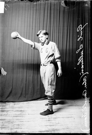 Charles Carroll indoor baseball player Cyril Sullivan holding a ball standing in front of a dark colored background - Chicago Daily News, Inc.