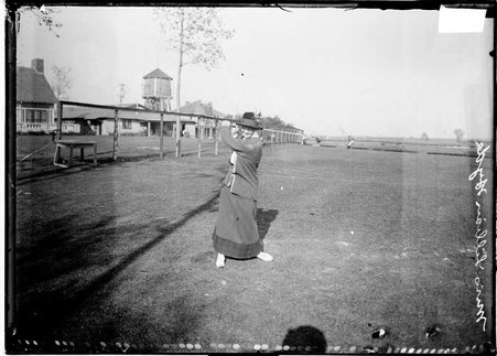 Golfer, Miss Lillian Hyde swinging club over right shoulder standing on driving range - Chicago Daily News, Inc.