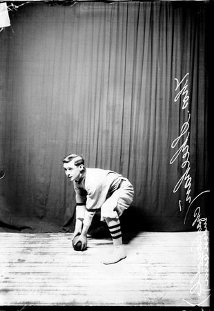 Charles Carroll indoor baseball player Thomas Sheehan holding a ball crouching in front of a dark colored background - Chicago Daily News, Inc.